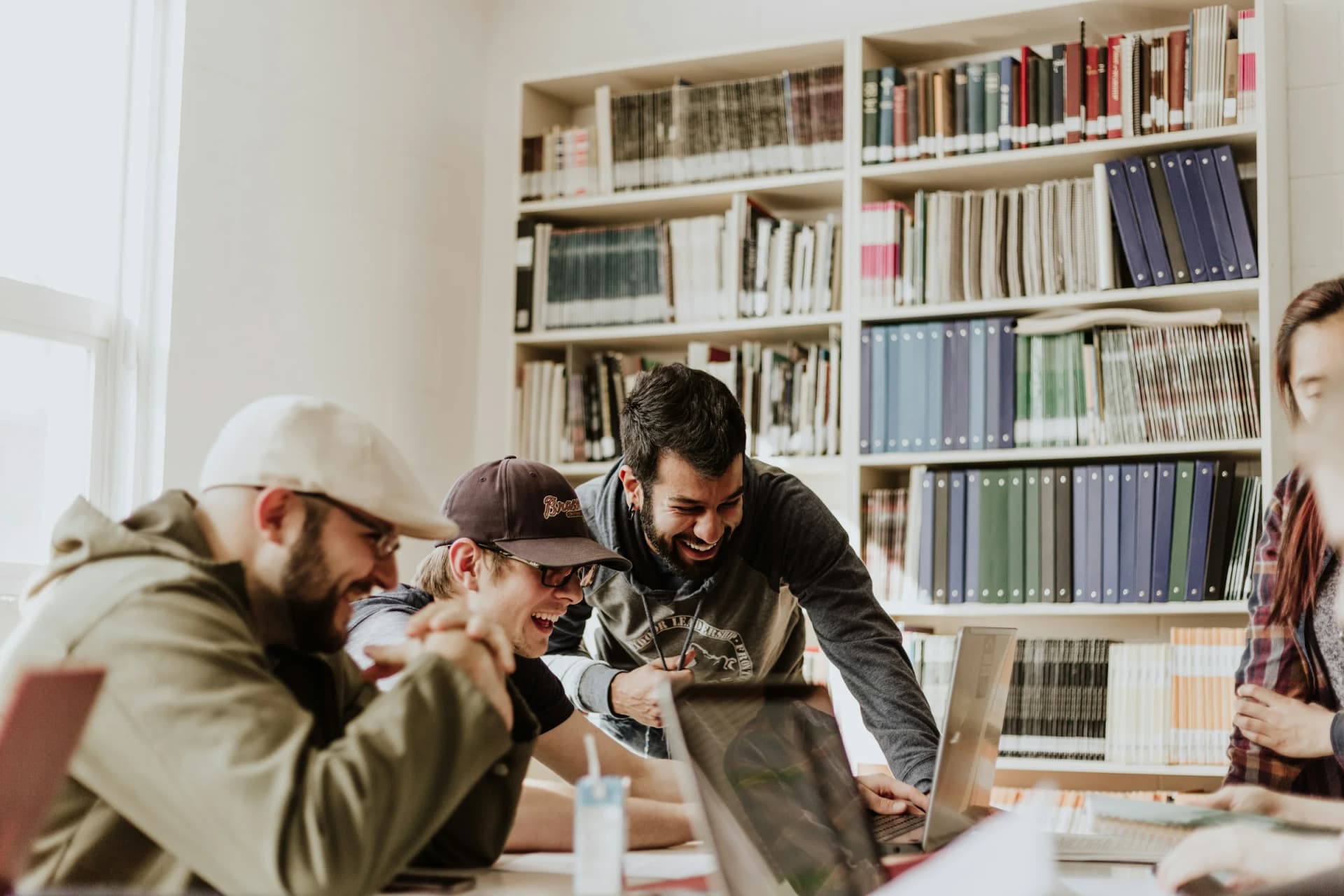 Students working together over a laptop in a university library