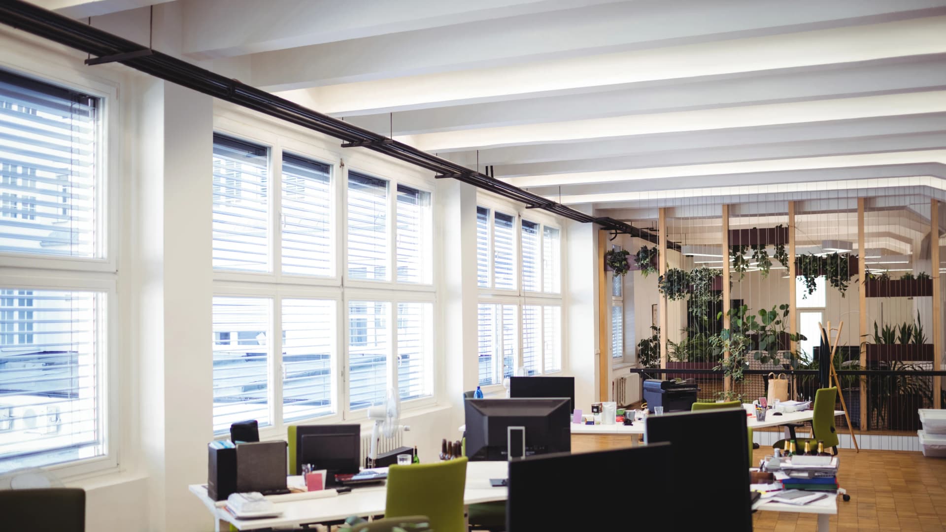 A bright open-plan office with desks and workstations ready for the day